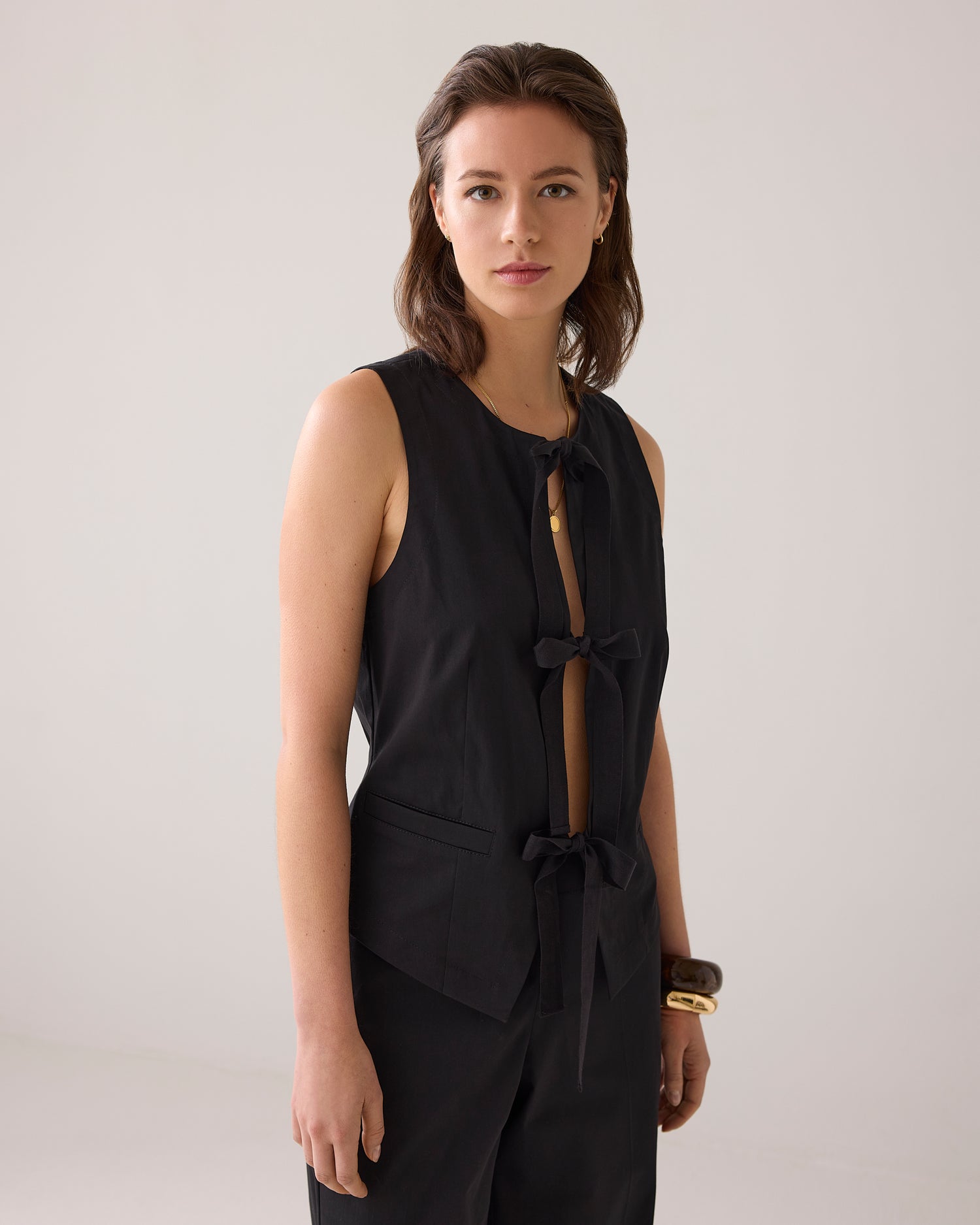 Fitted gilet with bow fastening